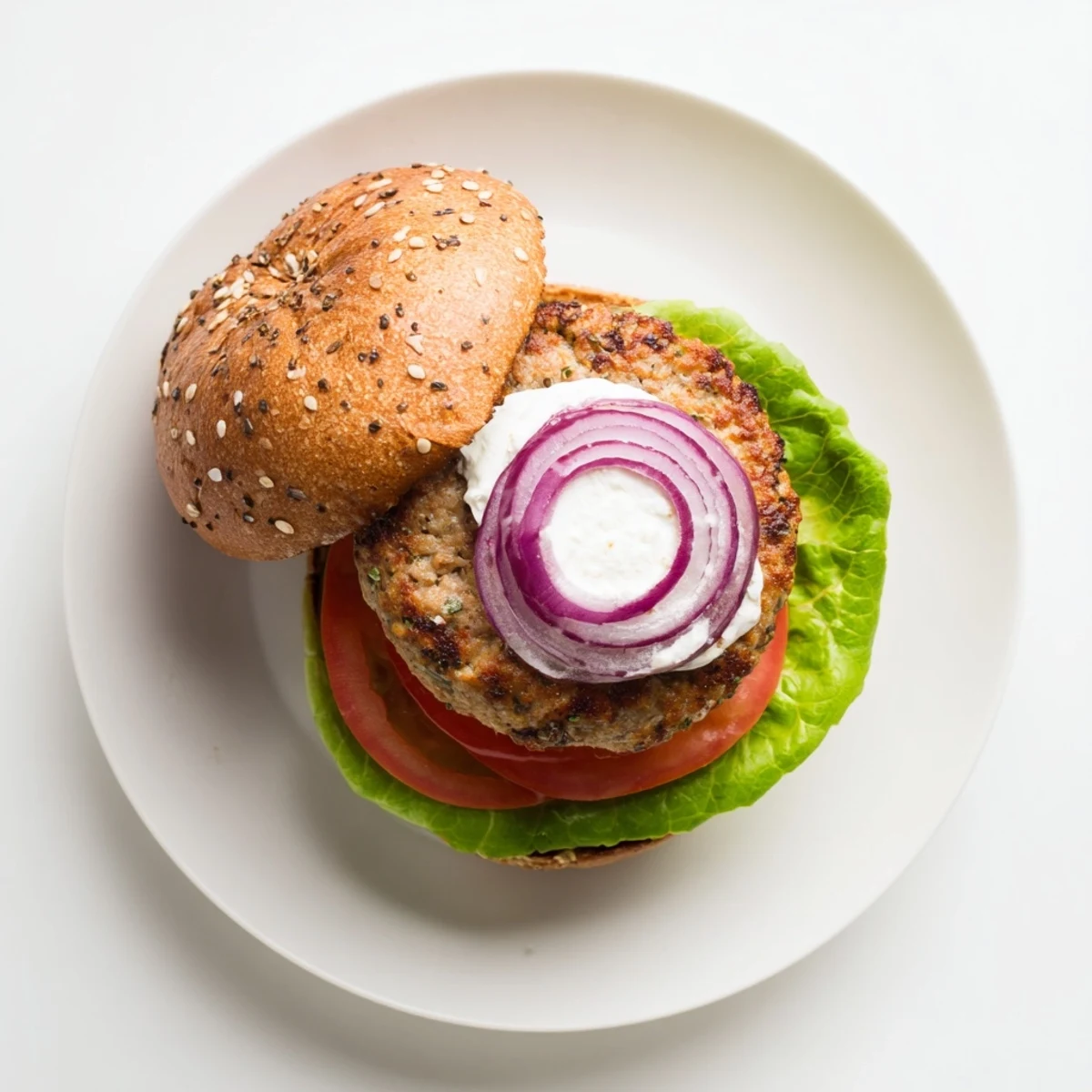 Juicy healthy high protein burger stacked with fresh lettuce tomato avocado on toasted whole wheat bun