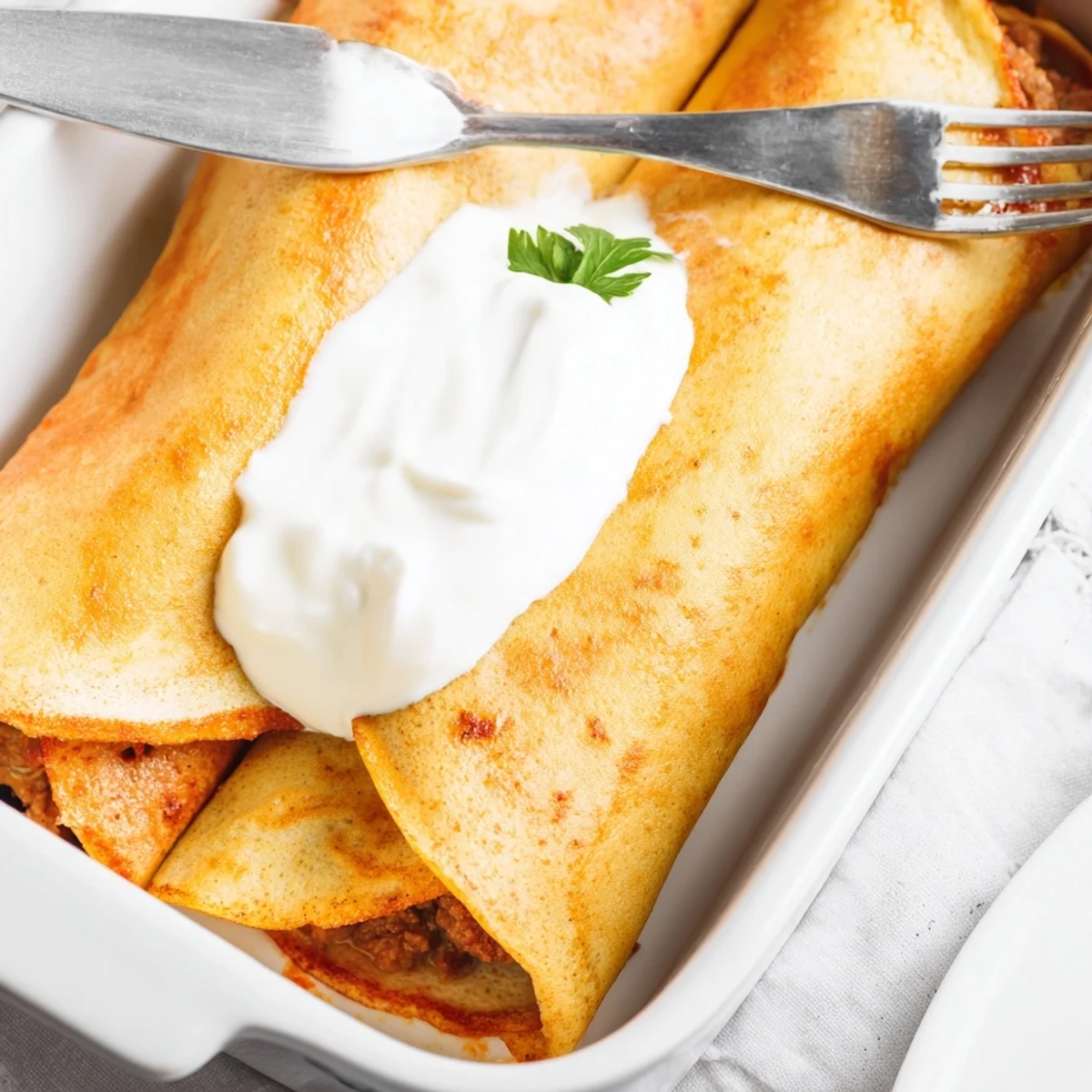 Baked Hortobágyi palacsinta casserole displaying golden crepes rolled around seasoned meat filling in rich cream sauce