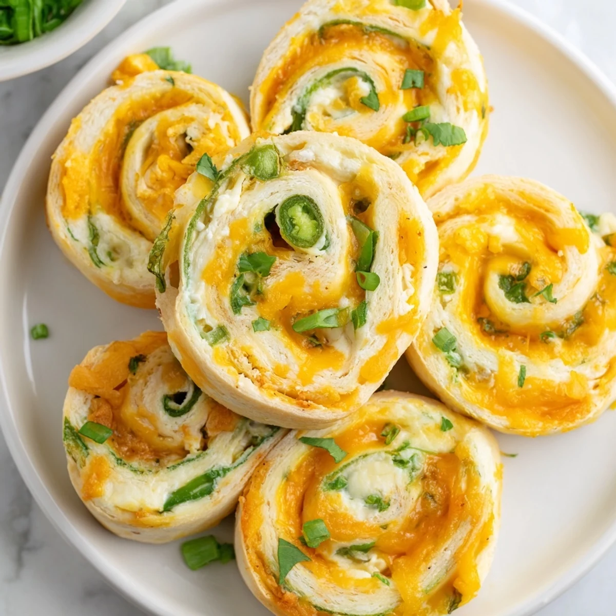 Spiral sliced Easy Jalapeno Popper Pinwheels showing creamy cheese and jalapeno filling inside warm flour tortillas