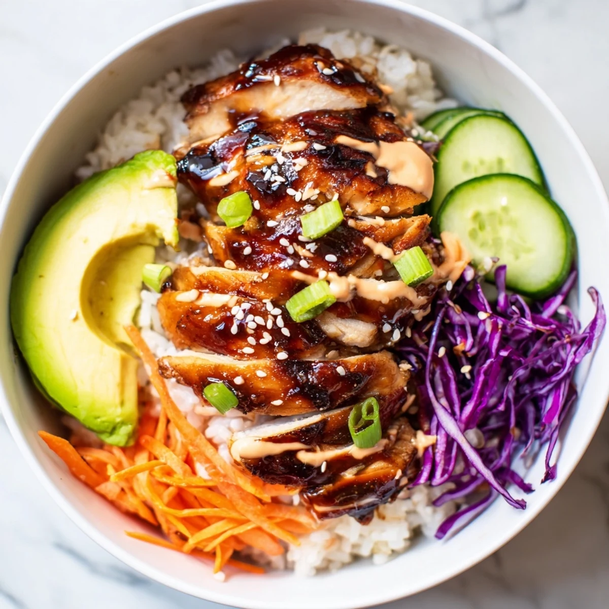 Savory Korean BBQ chicken bowl garnished with creamy spicy mayo avocado and crisp shredded cabbage