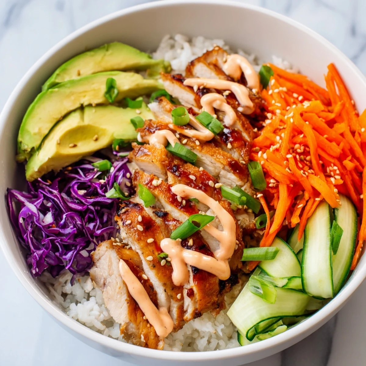 Vibrant bowl featuring marinated Korean BBQ chicken slices atop fluffy rice with fresh cucumber and carrots