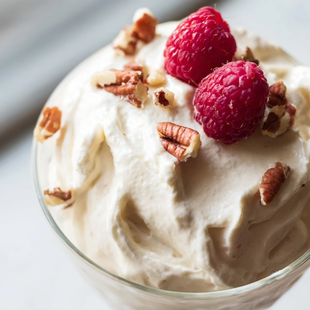 Creamy Keto Cheesecake Fluff topped with fresh berries in a glass serving dish