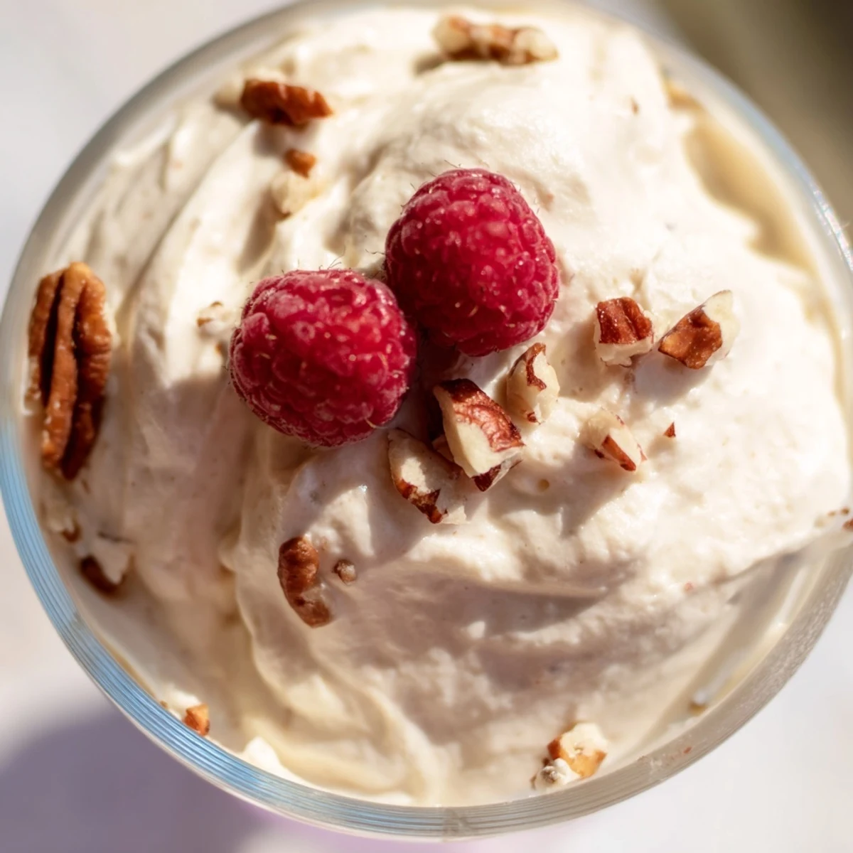 Light and airy Keto Cheesecake Fluff swirled with whipped cream and berries