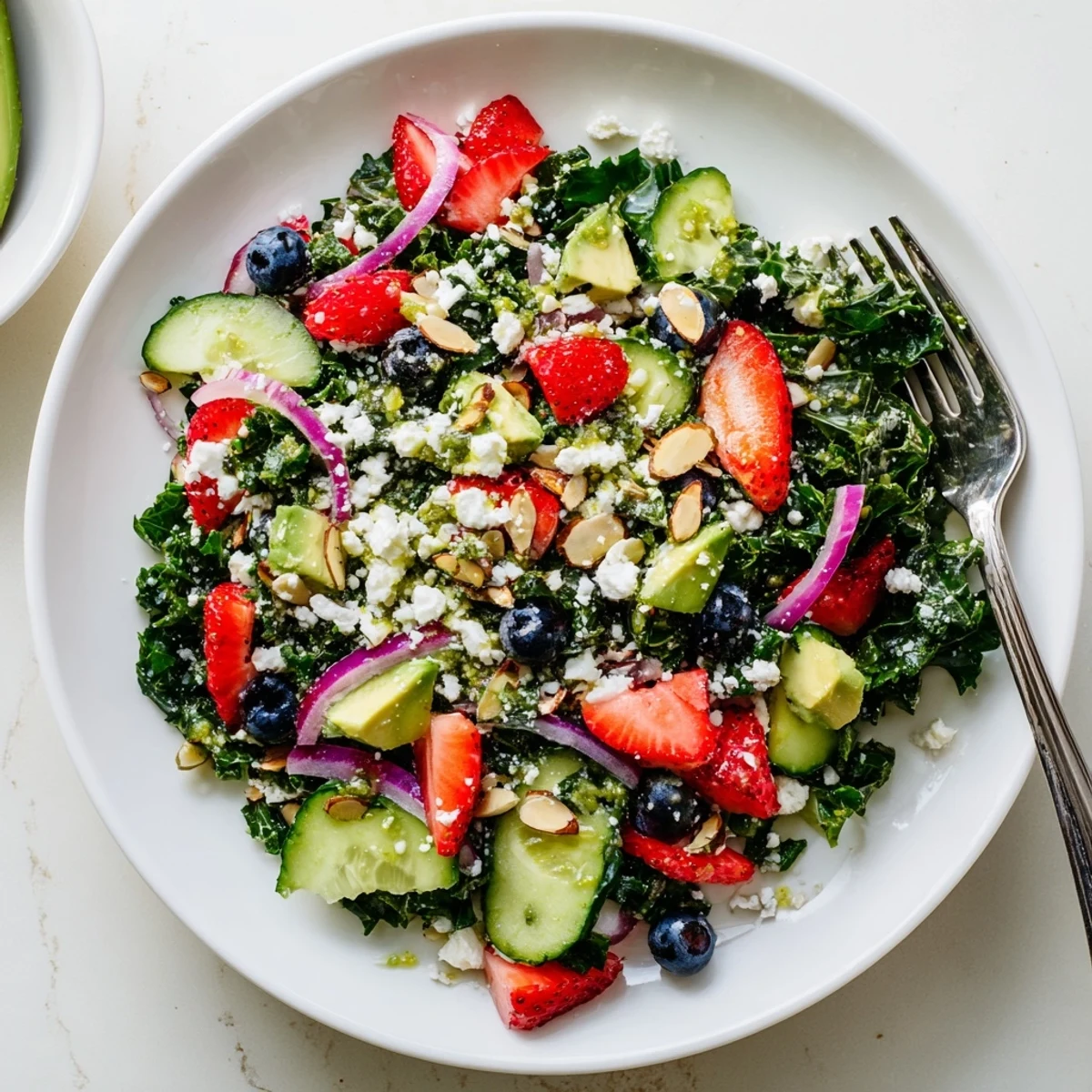 Chopped kale tossed with juicy strawberries, avocado, and blueberries drizzled with a golden lemon-honey vinaigrette.