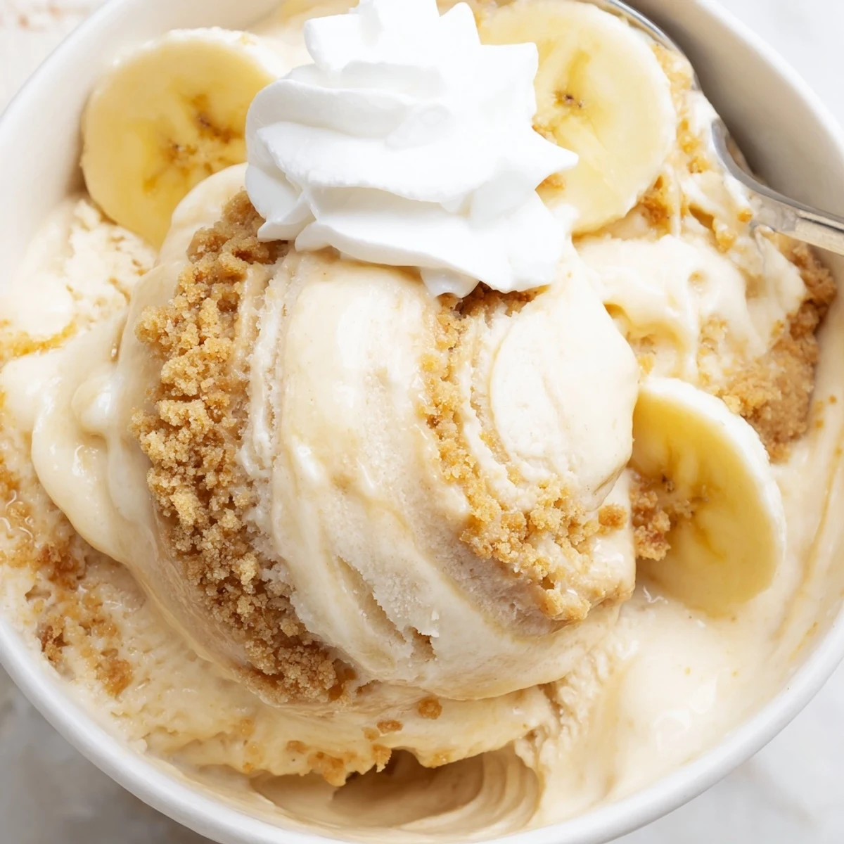 Aromatic vanilla Ninja Creami Banana Cream Pie Ice Cream topped with sliced bananas.