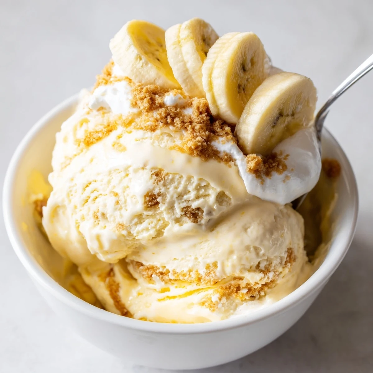 Spoon-ready Ninja Creami Banana Cream Pie Ice Cream after spinning, graham cracker swirl.