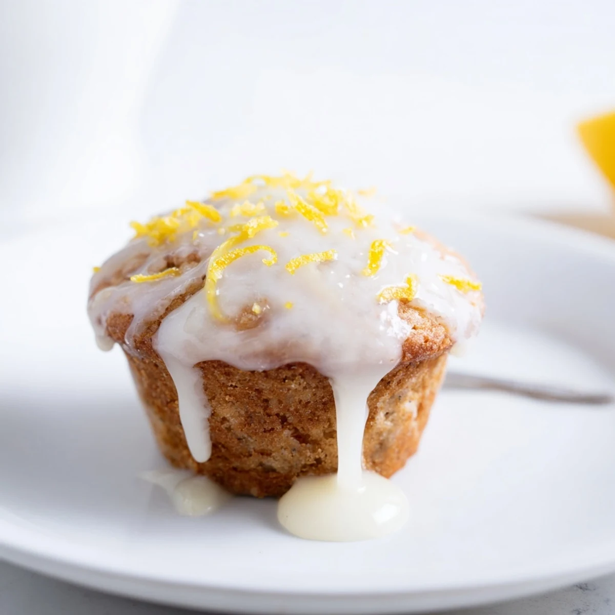 Freshly baked Glazed Lemon Ginger Muffins cooling on rack, drizzled with bright glaze