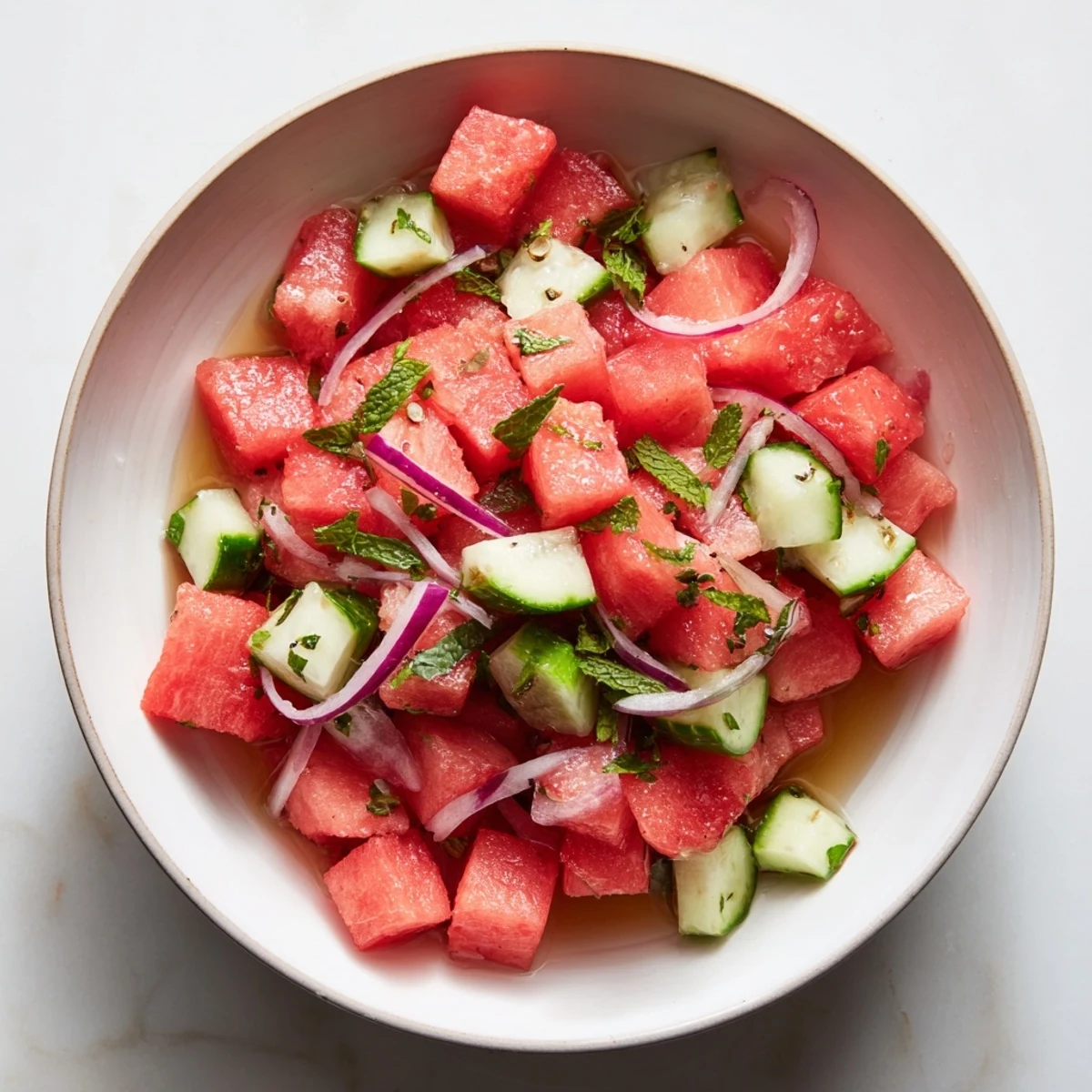 Watermelon Cucumber Salad with mint and lime, vibrant cubes glistening, picnic ready