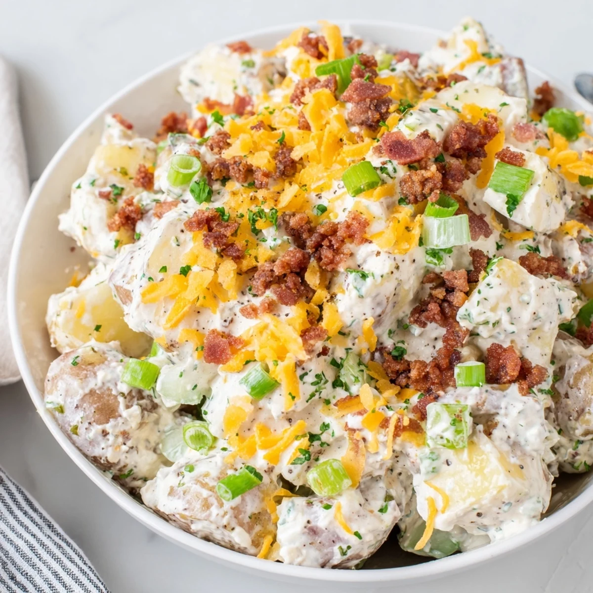 Warm Beef Bacon Loaded Potato Salad tossed with green onions, celery, tangy dressing
