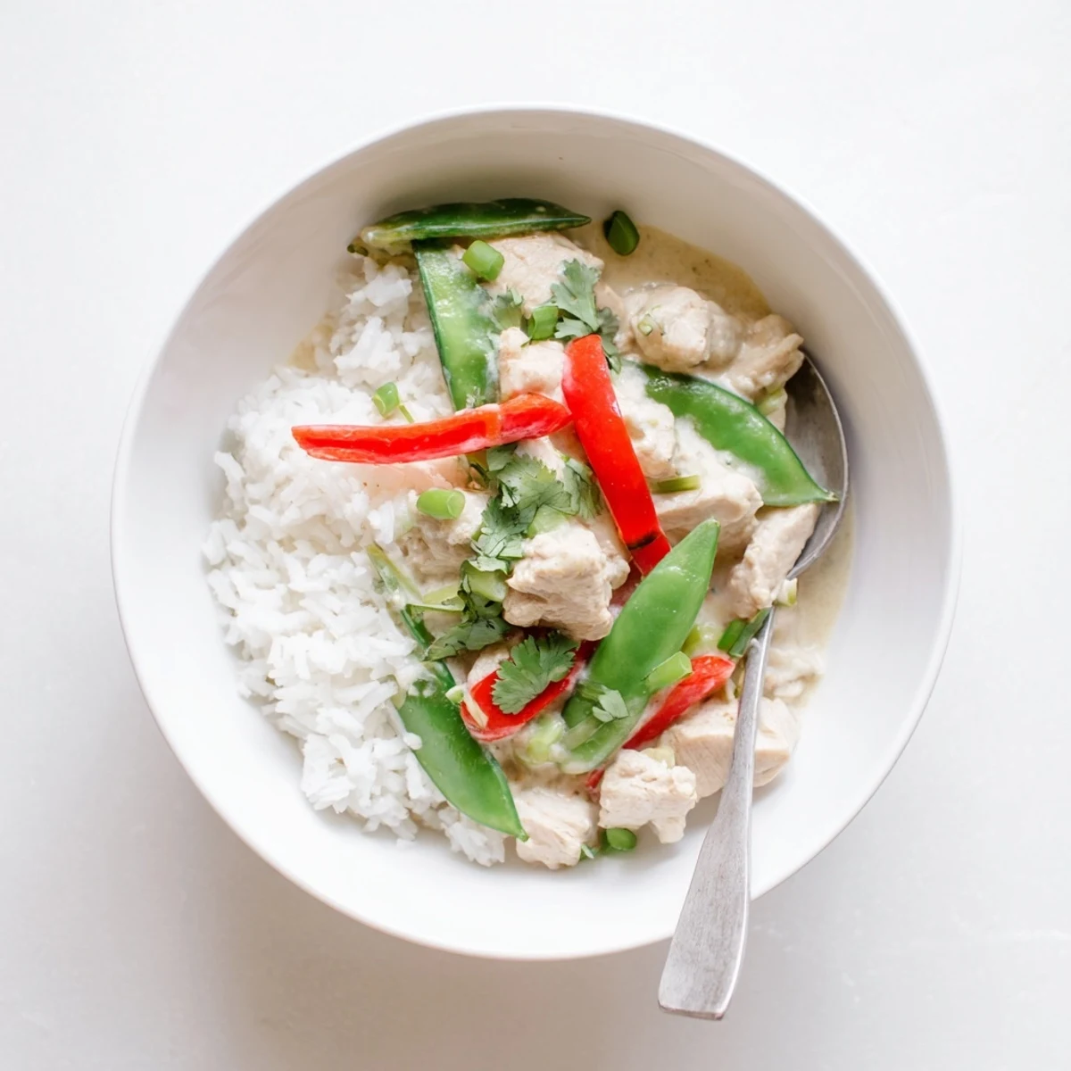 Rich coconut chicken bowl featuring tender meat in aromatic sauce over steamed white rice