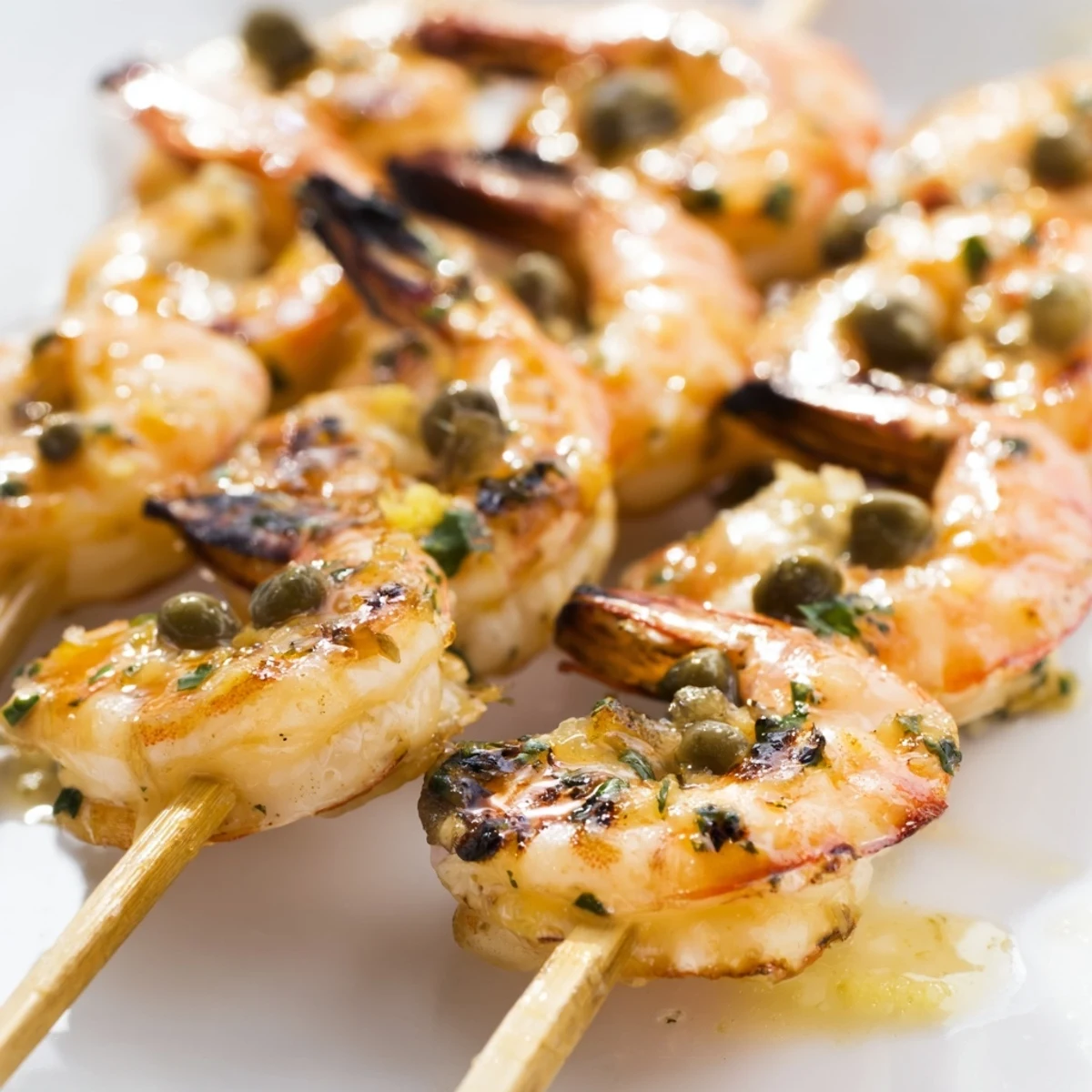 Golden grilled shrimp piccata skewers brushed with zesty lemon butter sauce and fresh parsley