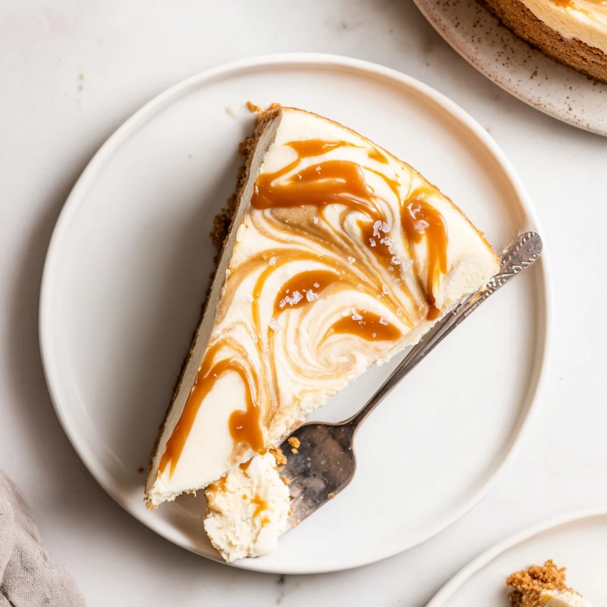 Homemade caramel swirl cheesecake featuring buttery graham cracker crust topped with sweet caramel sauce drizzle