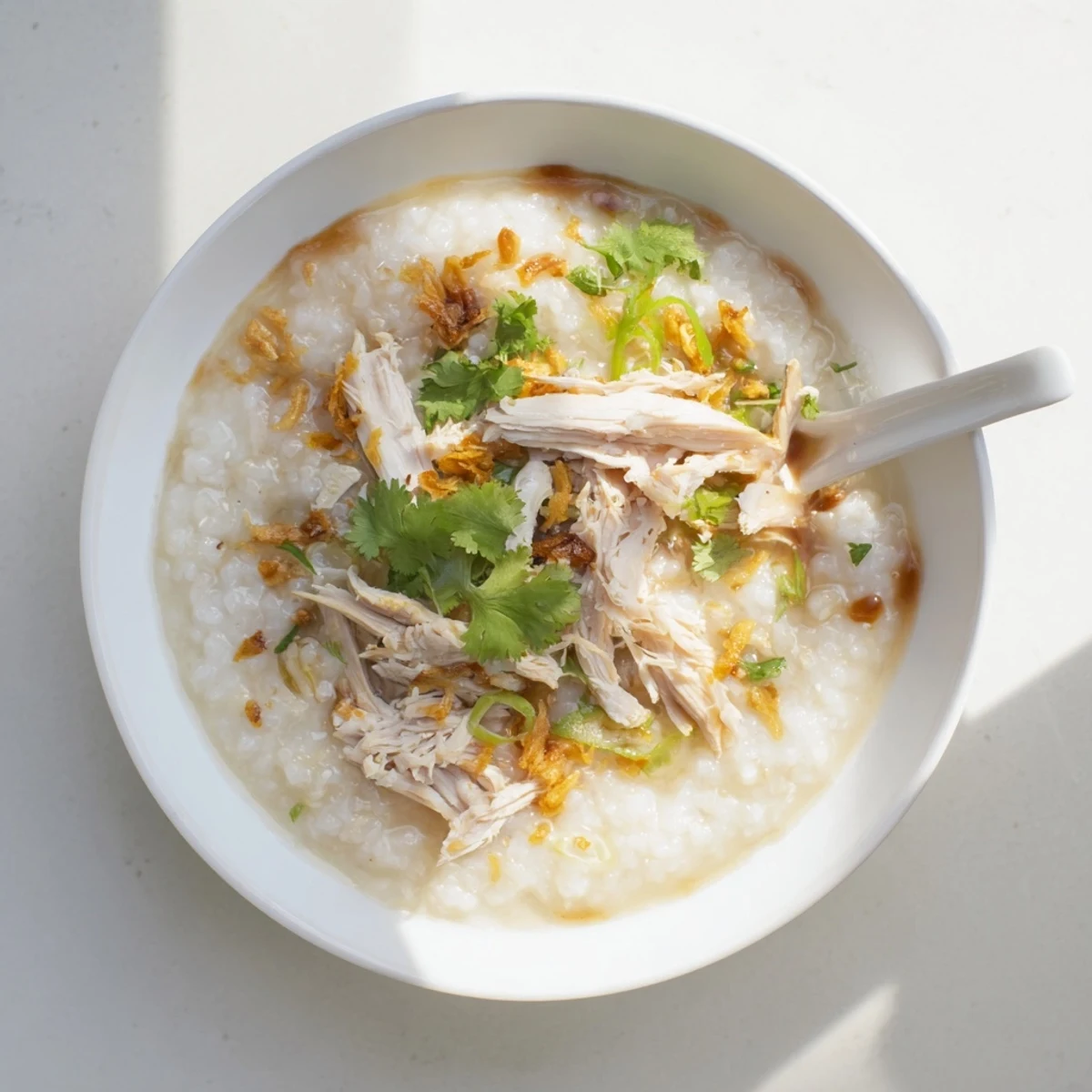 Savory chicken congee rice porridge with tender shredded chicken and sliced century eggs