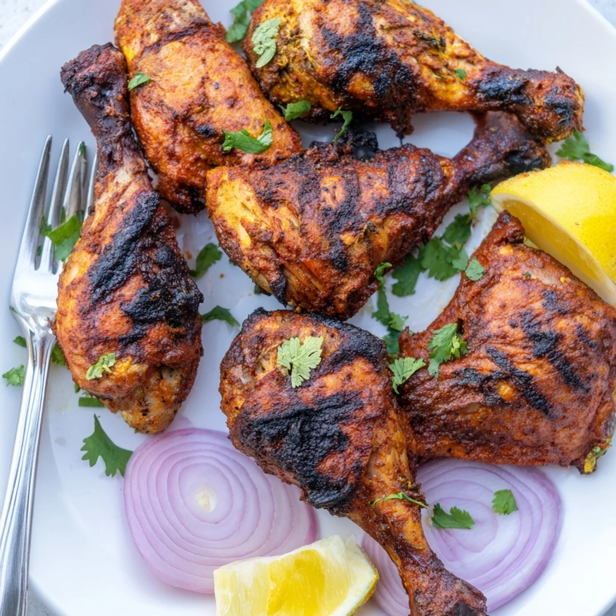 Juicy bone in Grilled Spicy Tandoori Chicken resting, sliced red onions and cilantro