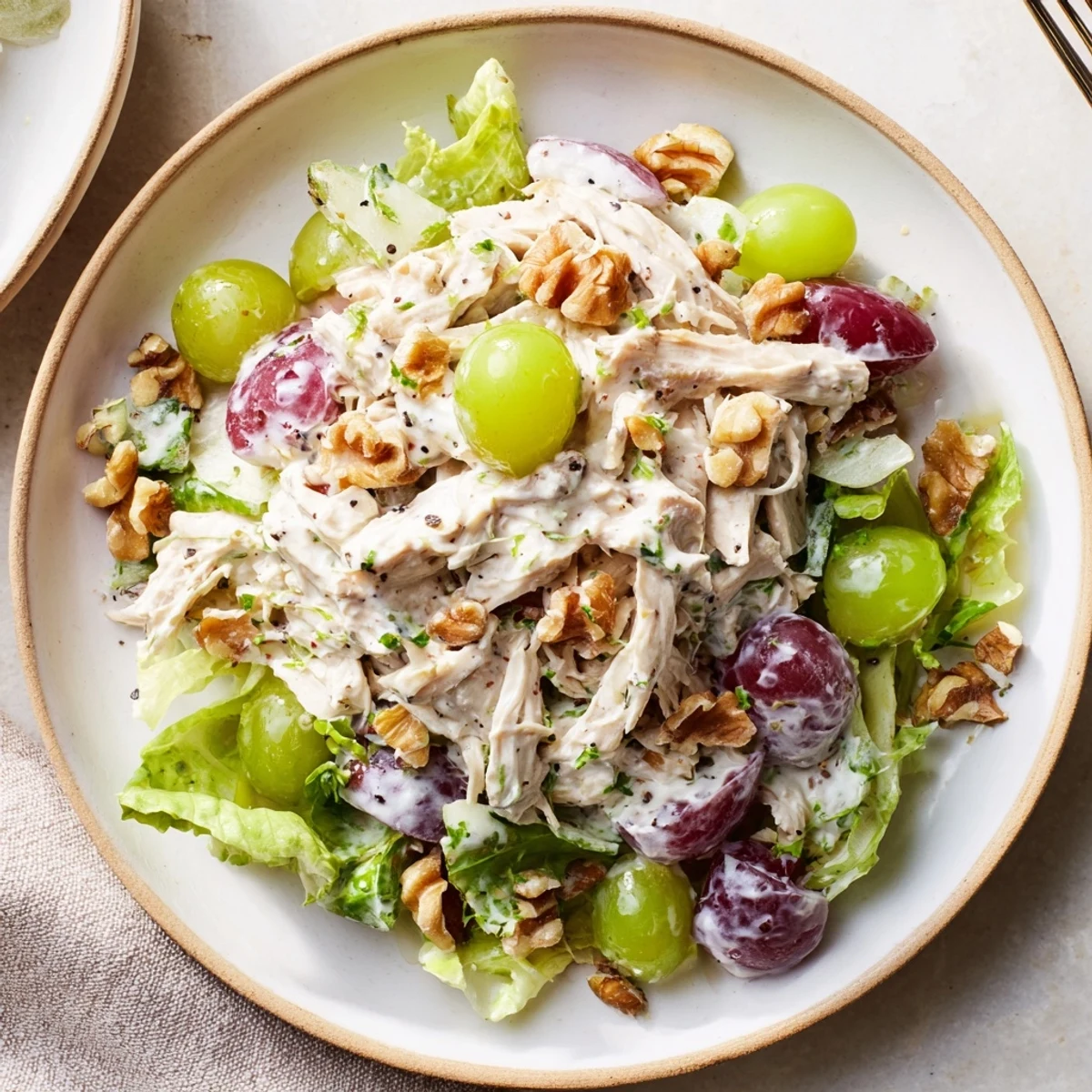 Chicken Salad With Creamy Yogurt Dressing piled on greens, grapes and crunchy walnuts  