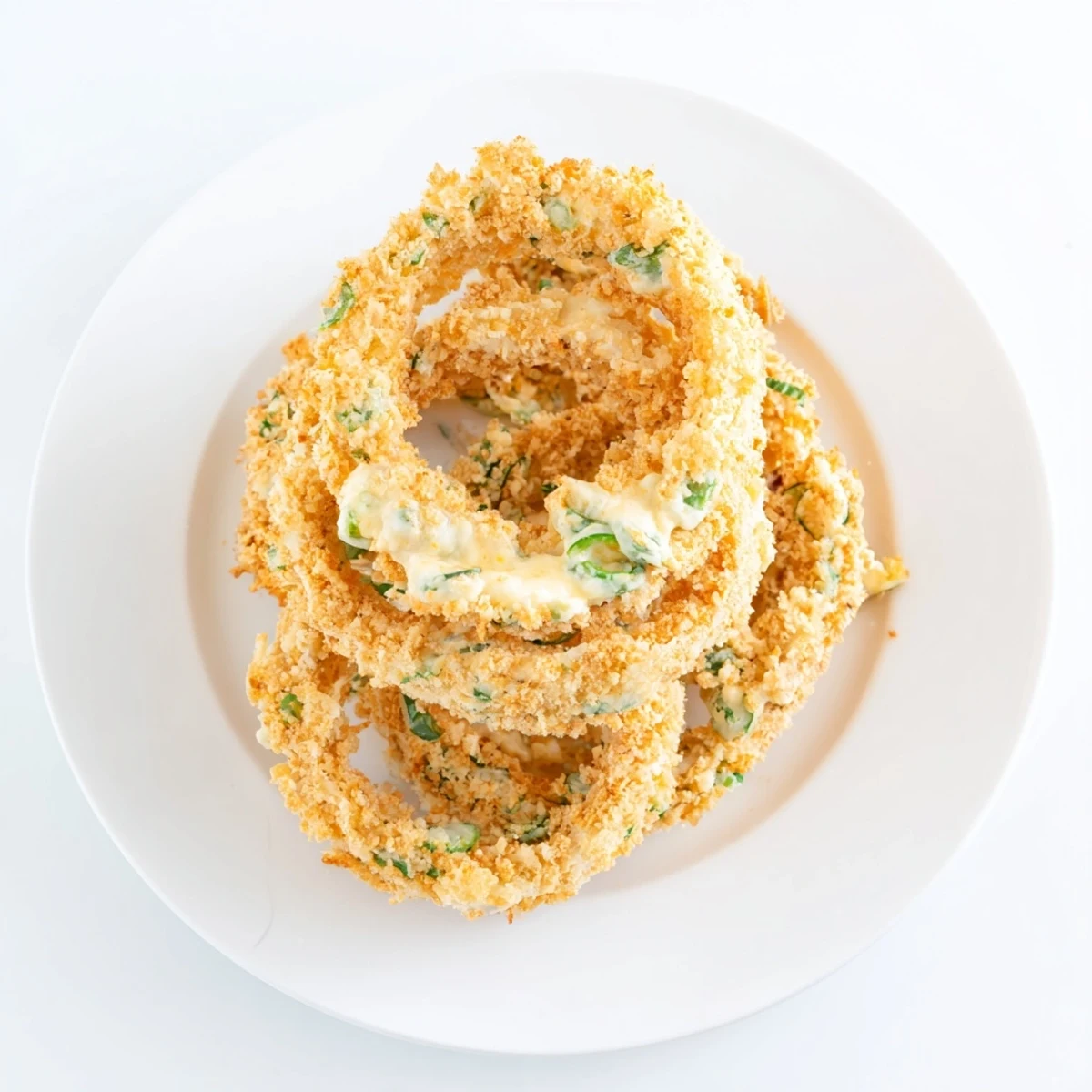 Fried onion rings with melted jalapeño cheese center on serving platter