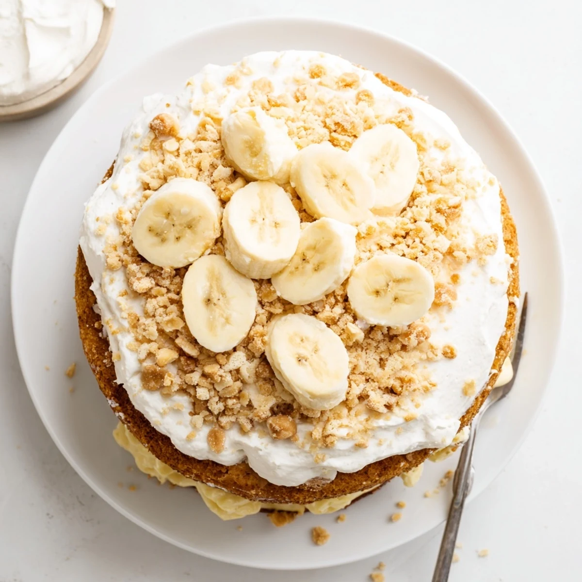 Southern-style banana pudding cake topped with whipped cream and crushed vanilla wafers