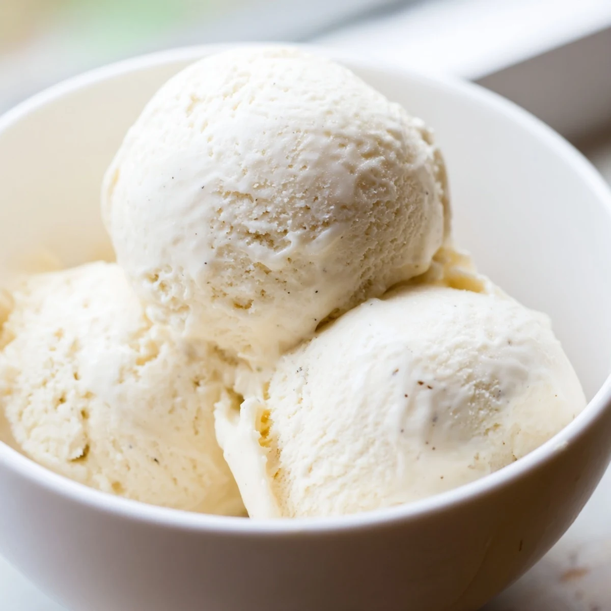 Rich homemade vanilla ice cream recipe served in a chilled glass dessert bowl