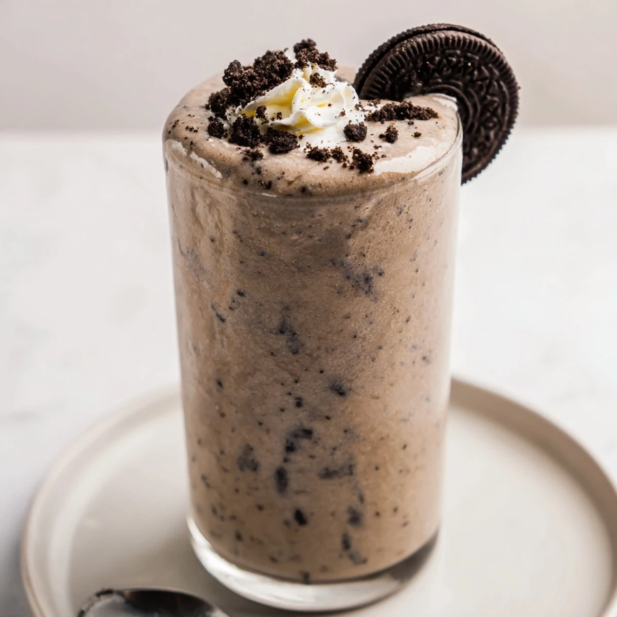 Frosty Cookies And Cream Protein Shake garnished with whipped cream and straw