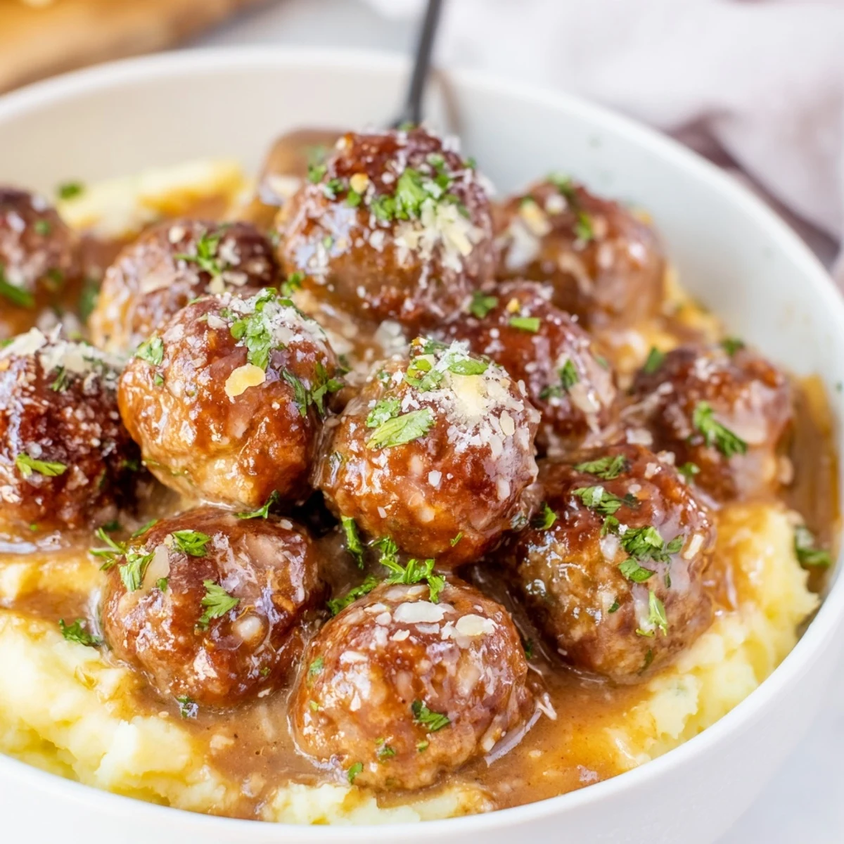 Slow-cooked Crockpot Meatballs Gravy bubbling in rich brown sauce, parsley.
