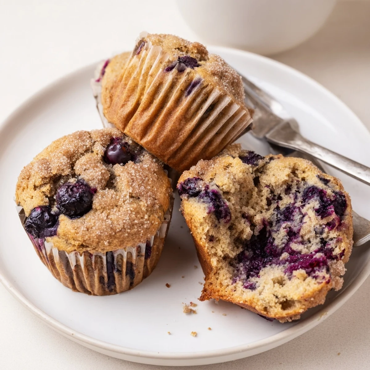 Blueberry Banana Muffins steaming on a wire rack, golden tops and bursting berries