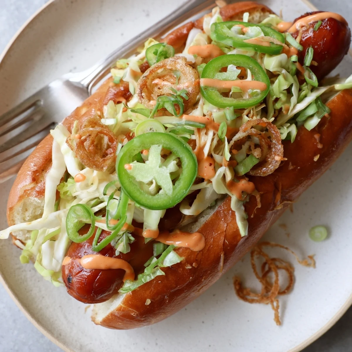 Spicy Firecracker Hot Dogs recipe served in toasted buns with creamy sauce drizzle