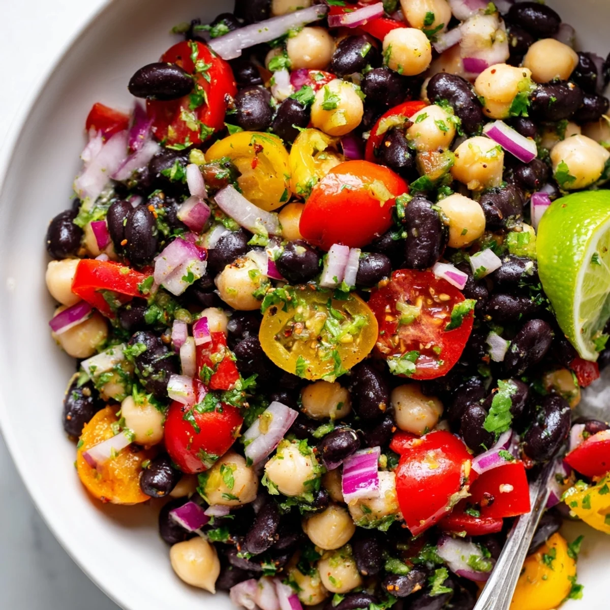 Serve Marinated Cilantro Lime Bean Salad chilled with tortilla chips and lime wedges
