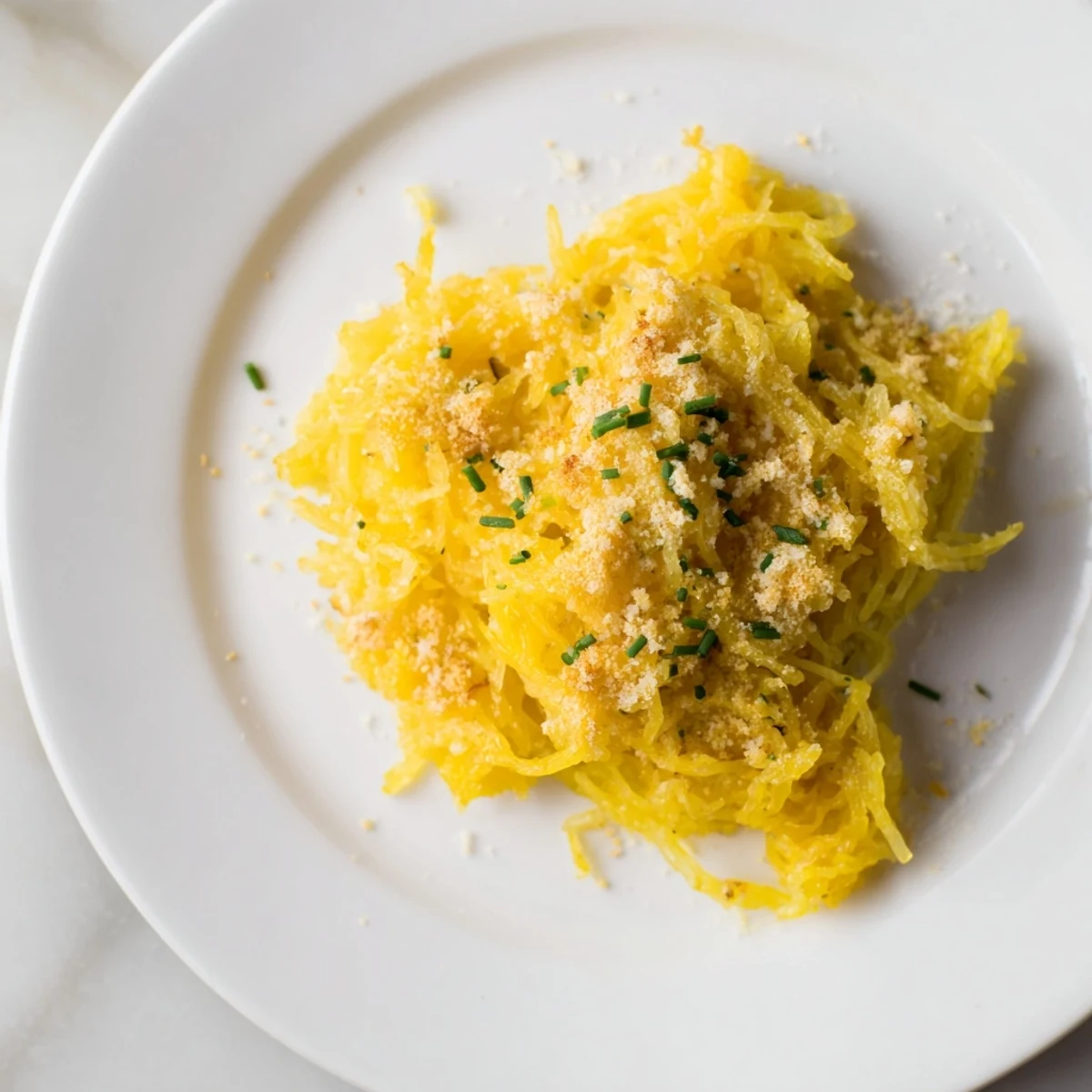 Steaming bowl of low-carb spaghetti squash mac and cheese topped with melted Parmesan and green parsley