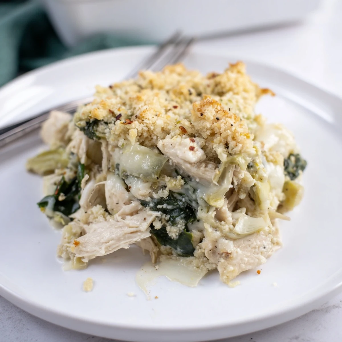 Spinach Artichoke Chicken Casserole bubbling with browned top and creamy filling