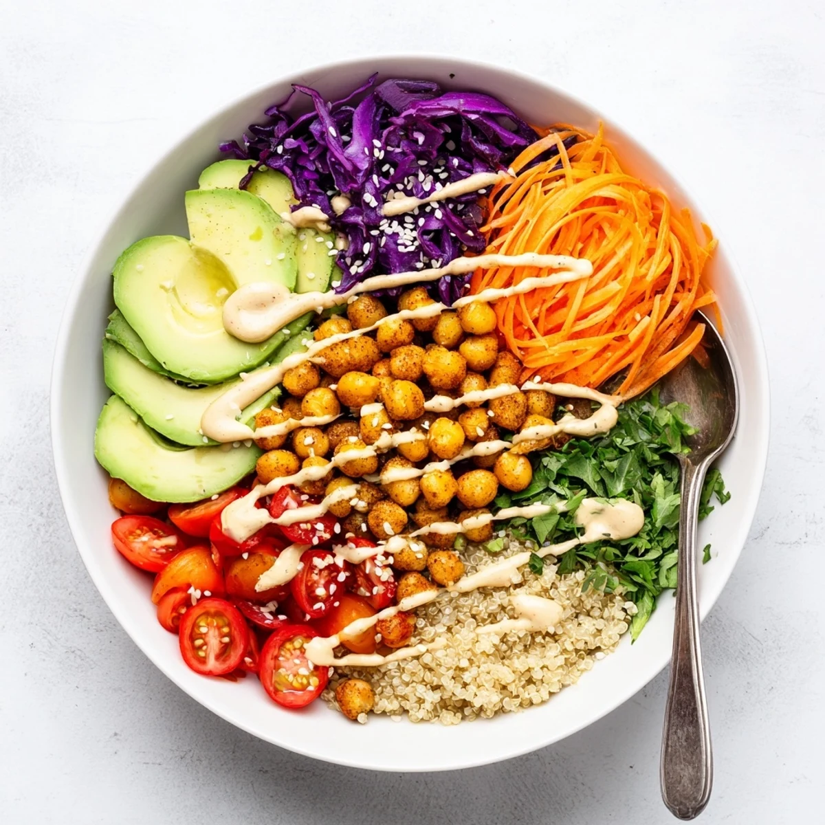 Hearty Buddha Bowl topped with fluffy quinoa, shredded cabbage, and drizzled tahini