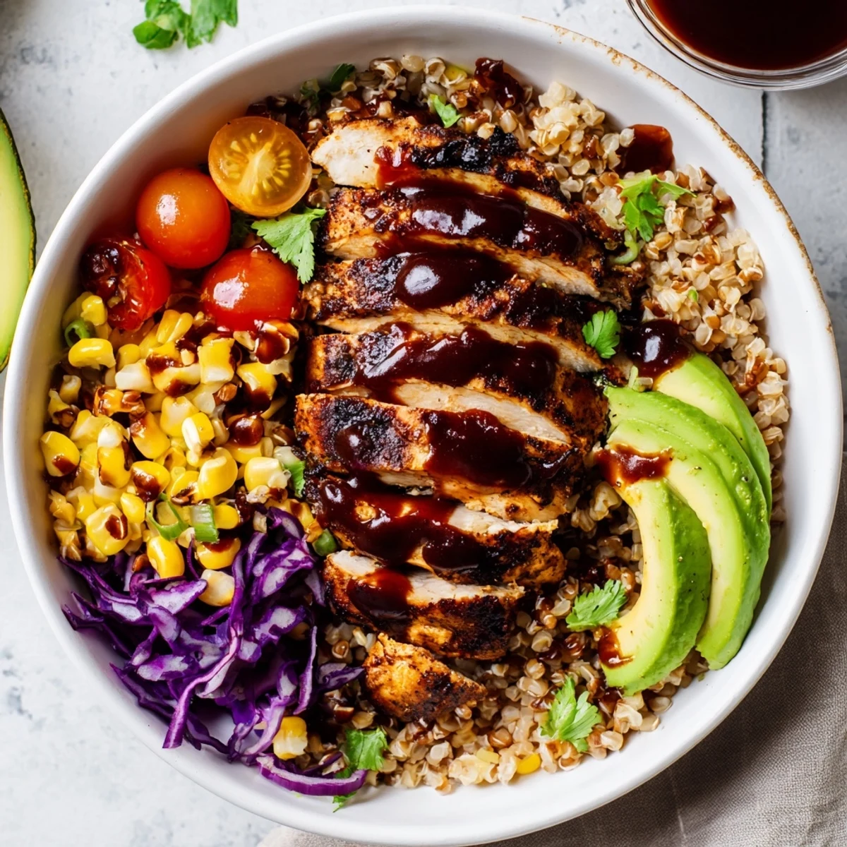 Barbecue chicken grain bowl served over fluffy brown rice with vibrant toppings