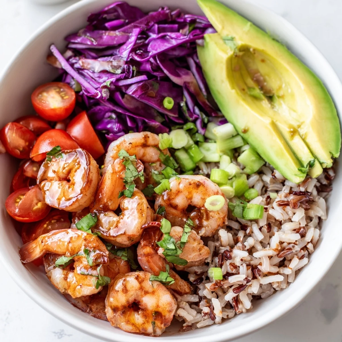 Colorful shrimp grain bowl featuring crisp cabbage, fresh cilantro, and tender rice