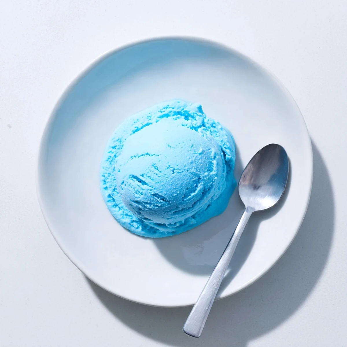 Creamy blue moon ice cream scooped into a crispy waffle cone with colorful sprinkles