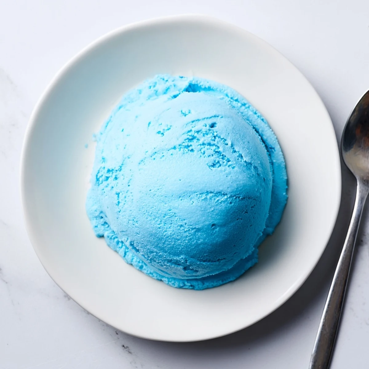 Vibrant blue moon ice cream served in a bowl showing its smooth velvety texture