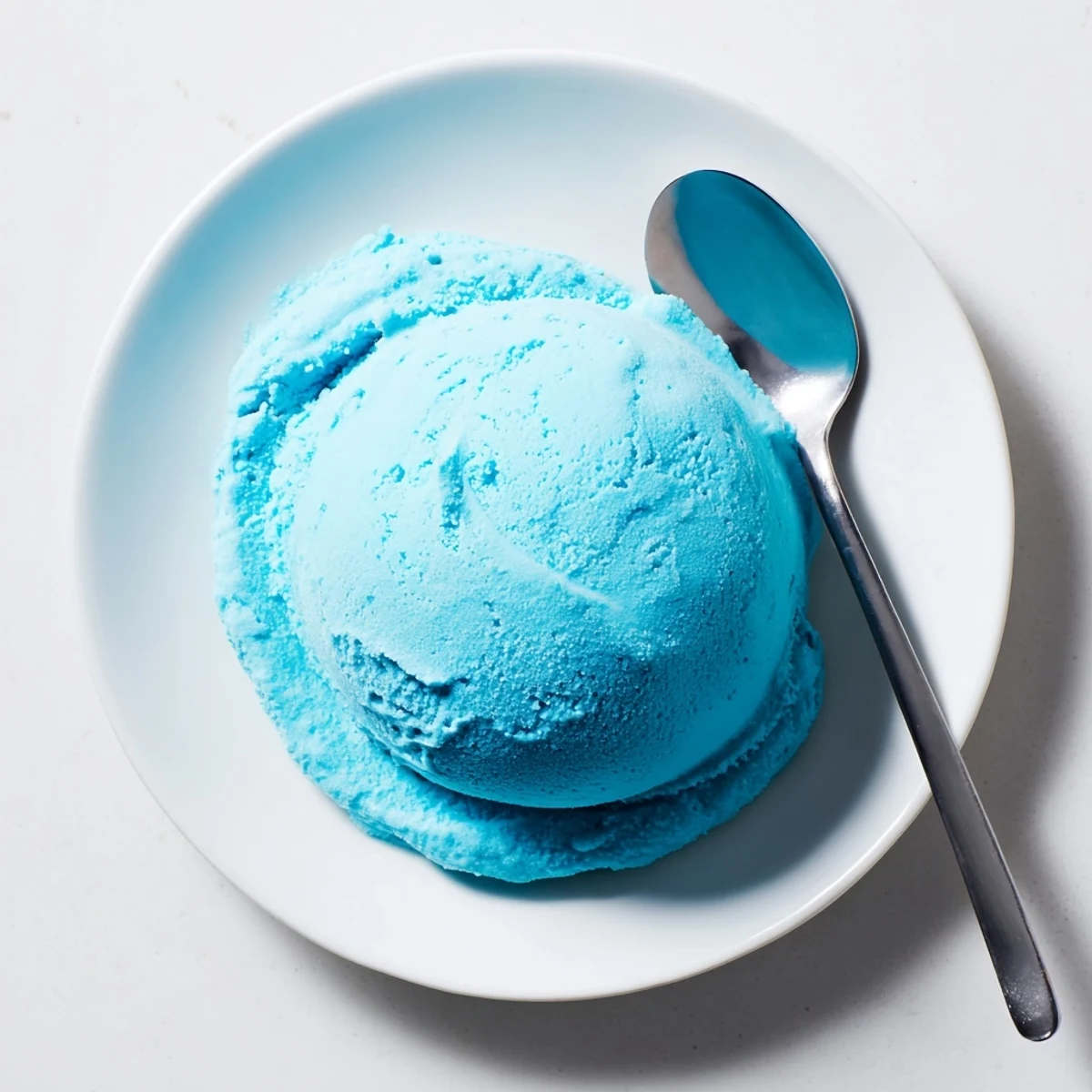 Homemade blue moon ice cream with a rich creamy swirl resting in a summer-ready cone