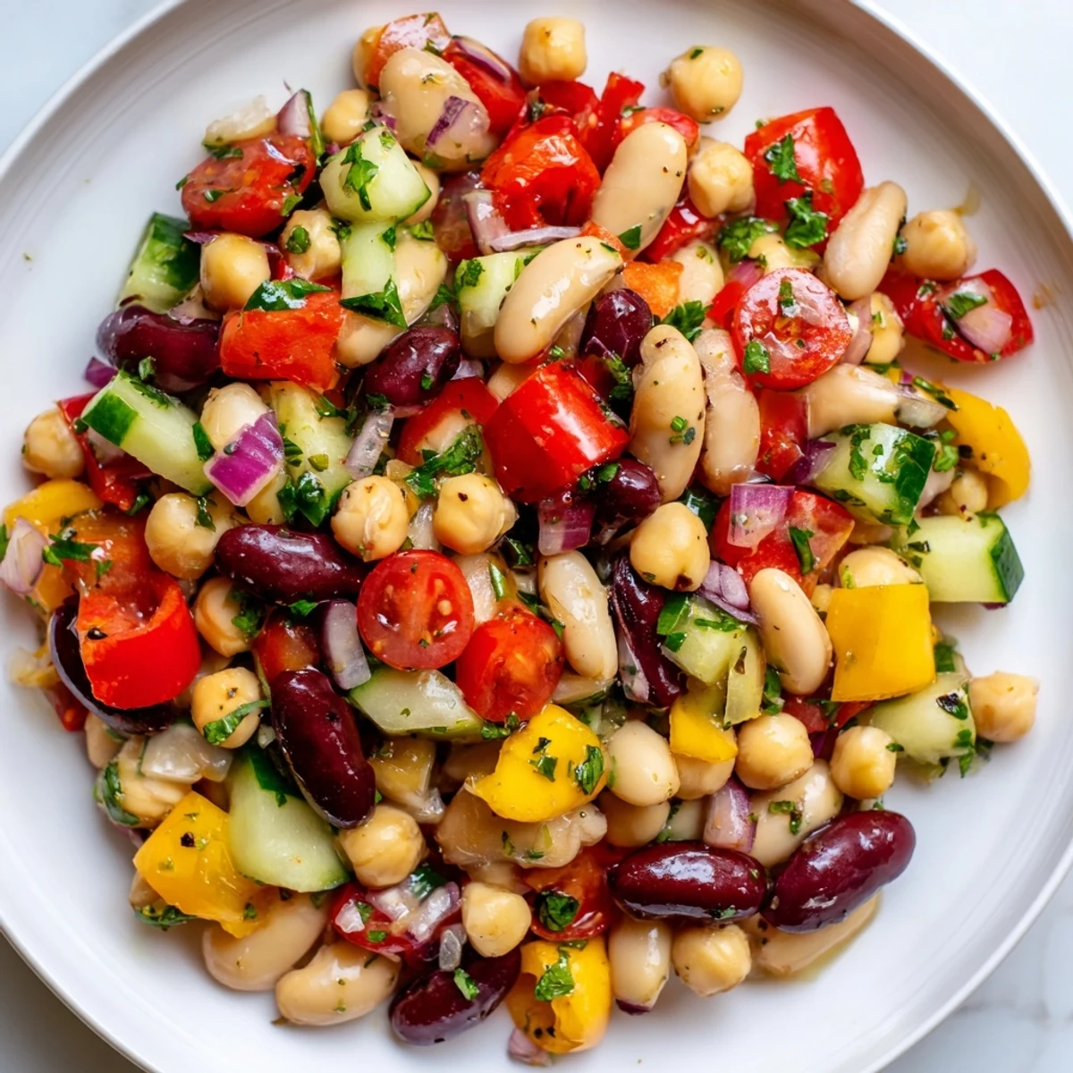 Colorful Italian bean salad tossed with crisp peppers and a tangy vinaigrette in a serving bowl.