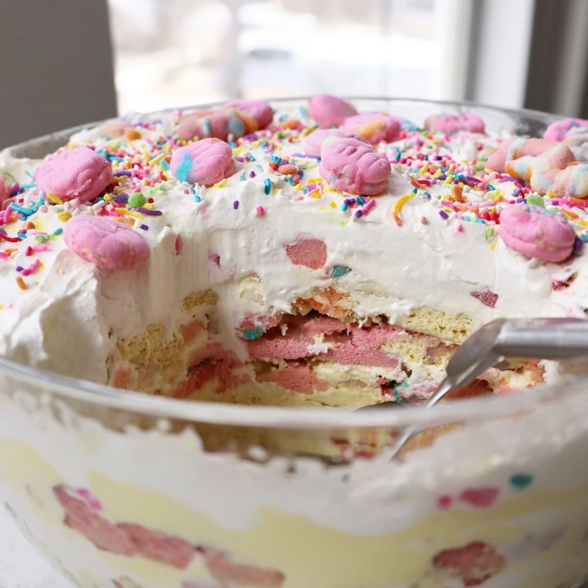 Creamy Circus Animal Cookie Lush layered dessert with pastel sprinkles in a glass baking dish