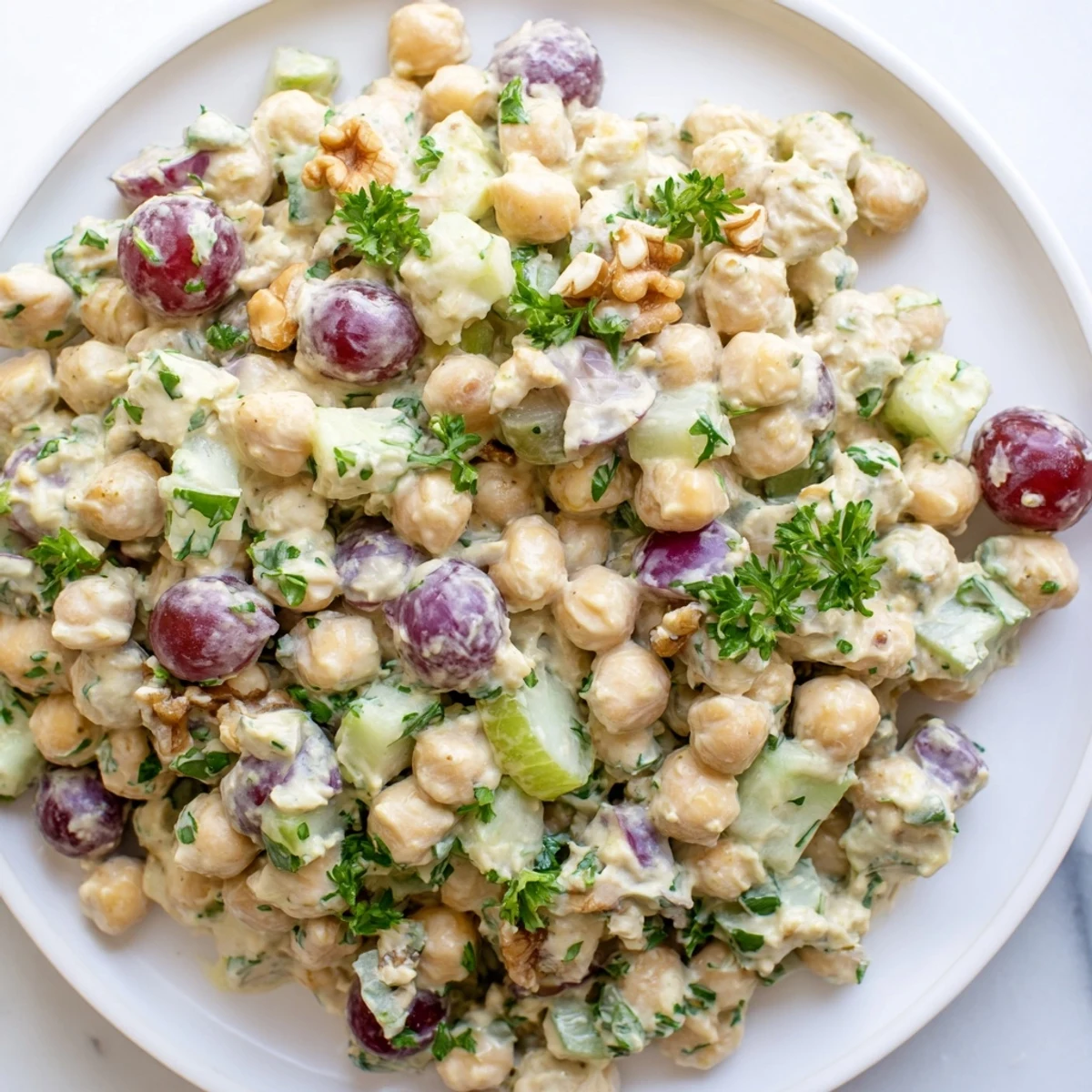 Creamy vegan chicken salad piled on toasted bread with crisp celery and grapes