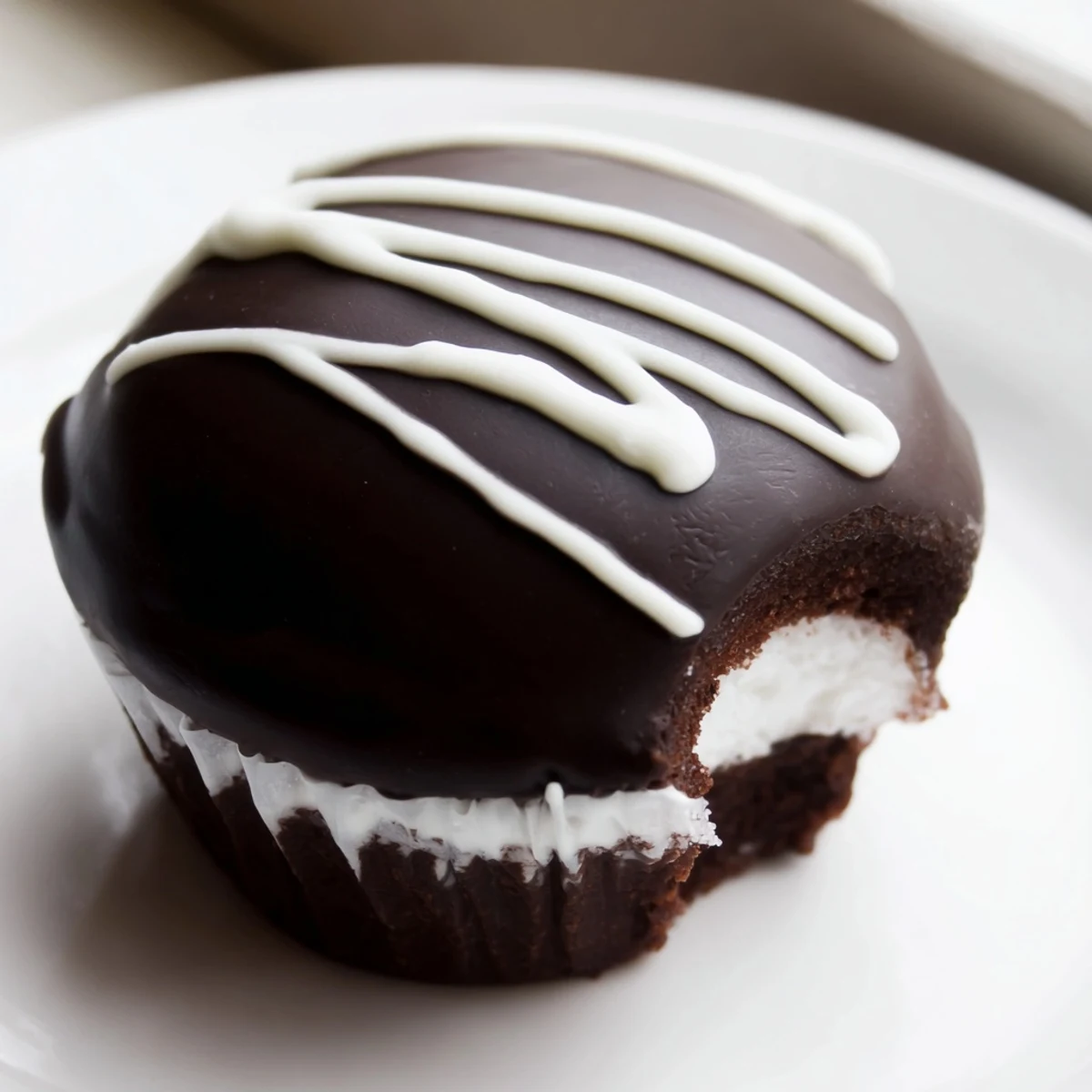 Rich Homemade Hostess Cupcakes featuring dark ganache drips and the classic white swirl