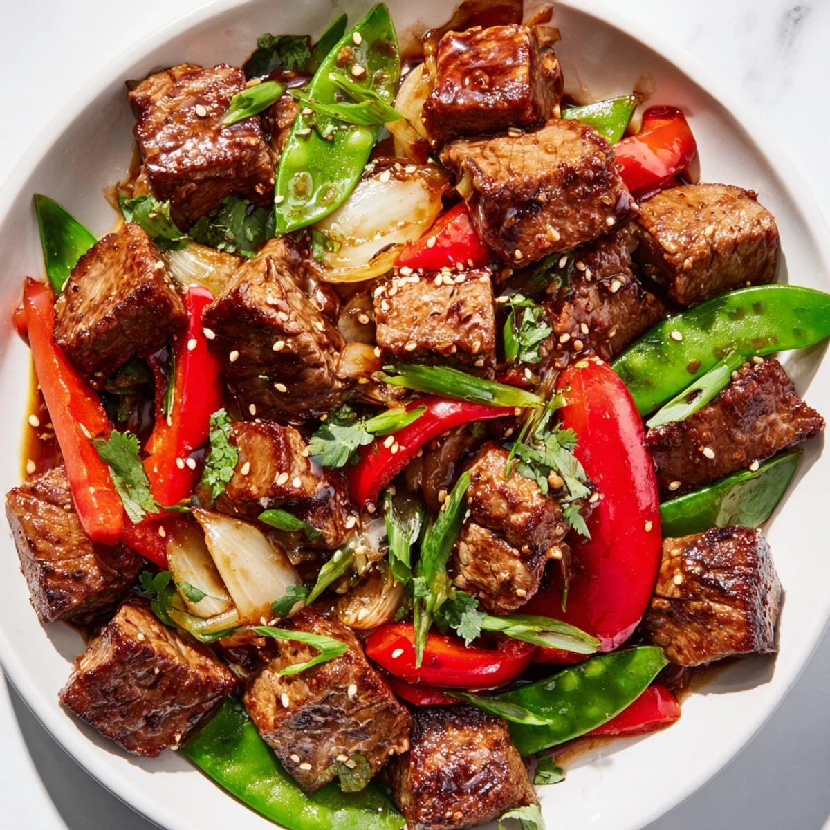 Pan-seared Asian-inspired cube steak topped with sesame seeds and served over colorful bell peppers