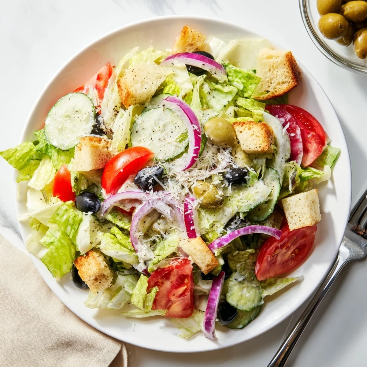 Golden garlic croutons crowning a vibrant Olive Garden Salad in a rustic wooden bowl.