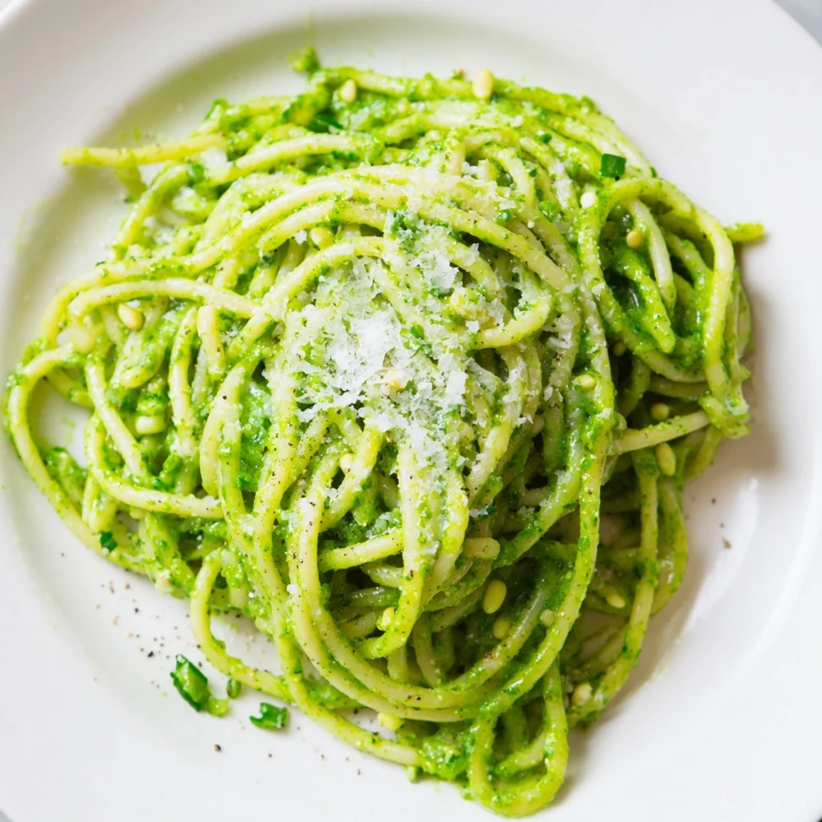 Wild garlic pesto pasta twirled on a fork with shaved Parmesan on top