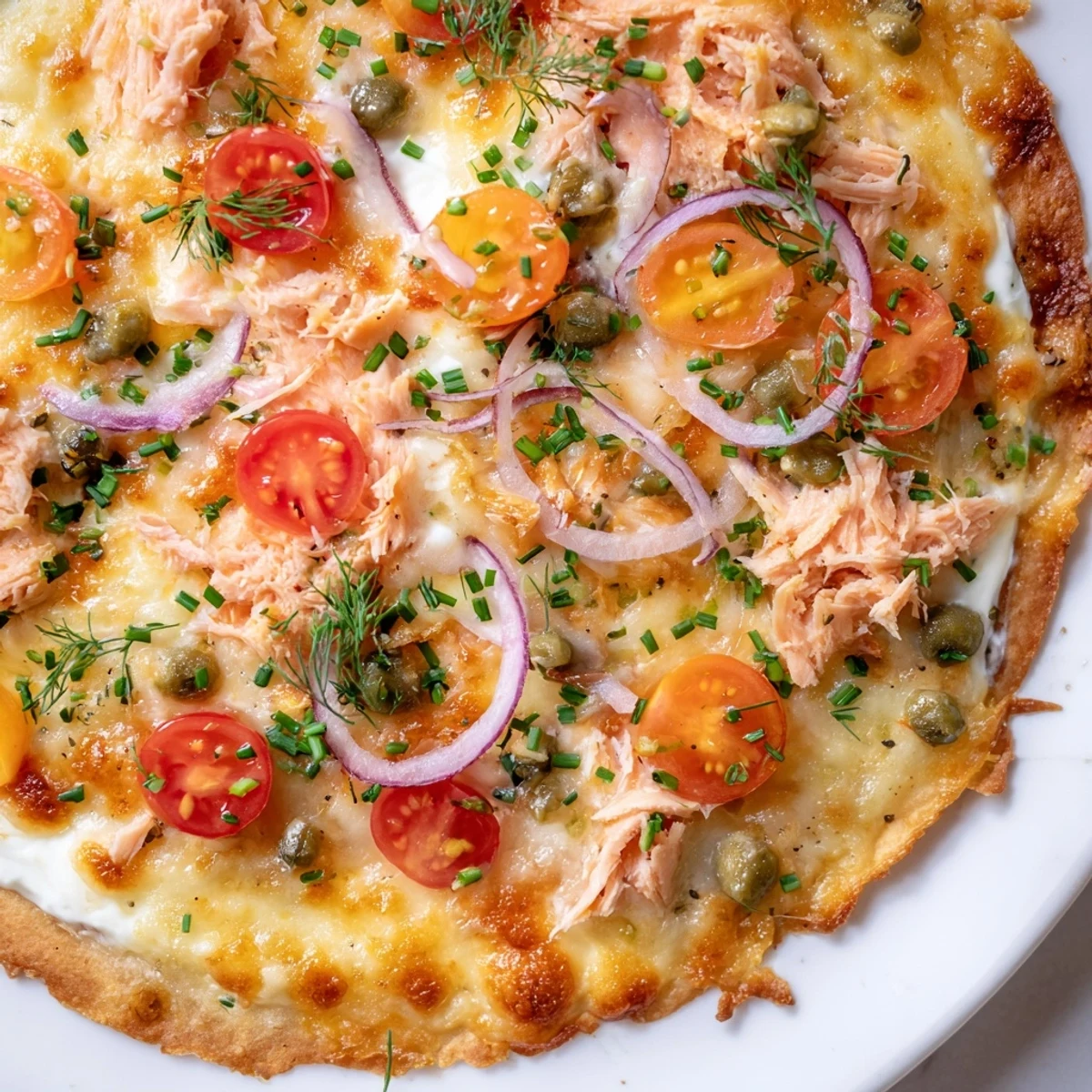 Crispy leftover salmon tortilla pizza with melted mozzarella and fresh dill garnish