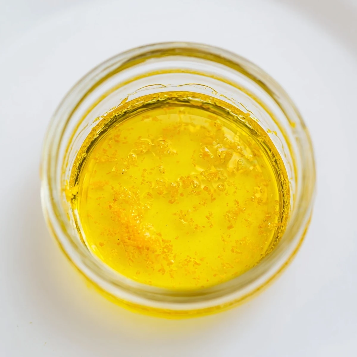 Zesty lemon vinaigrette dressing recipe in a glass jar with fresh herbs.  
