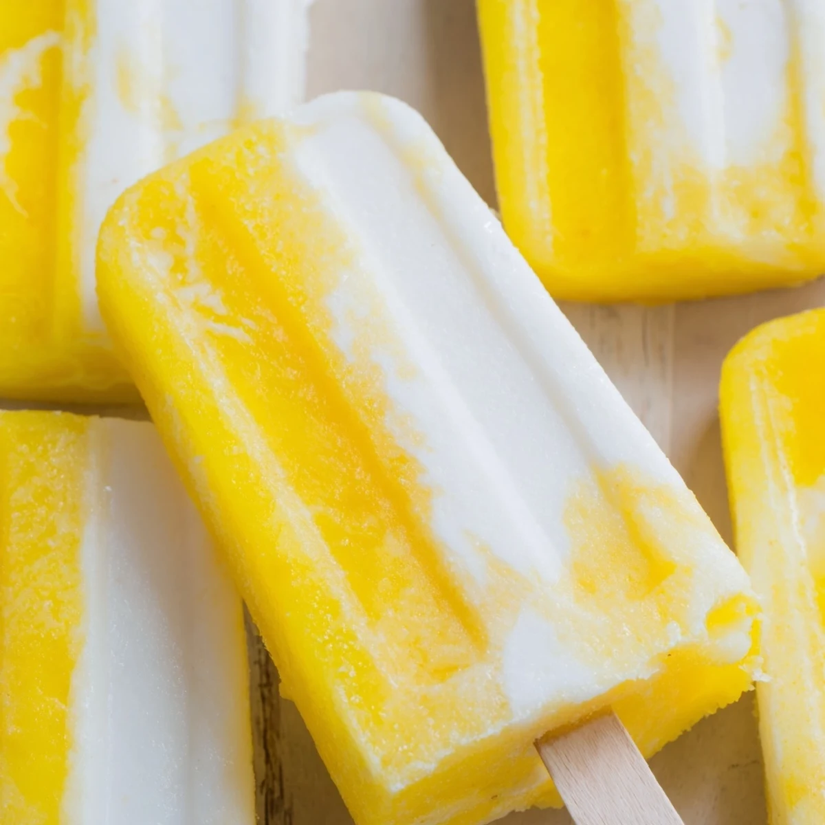 Creamy pineapple coconut lime popsicles featuring sweet fruit swirls perfect for summer treats.