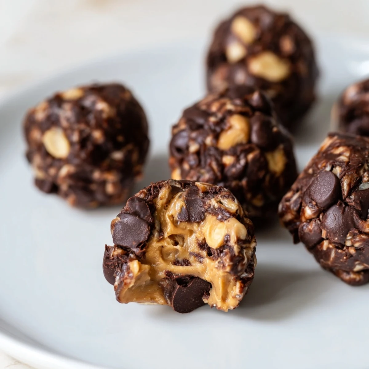Bite-sized Snickers energy balls featuring creamy peanut butter and oats in a bowl.  
