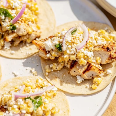 Crazy Good Street Corn Chicken Tacos garnished with fresh cilantro and lime.